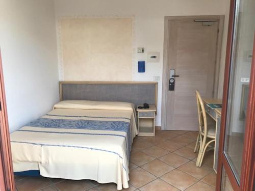 a bedroom with two beds and a table and a door at Hotel Mon Repos in Baja Sardinia