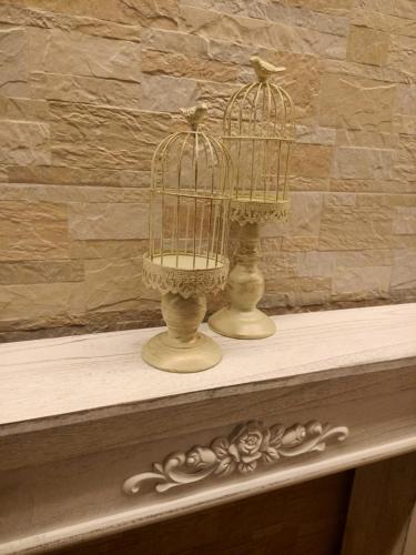 two bird cages sitting on top of a table at Hotel Verona in Caorle