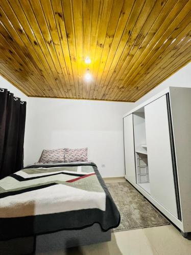 ein Schlafzimmer mit einem Bett und einer Holzdecke in der Unterkunft Cantinho do Nono 2 in Campos do Jordão