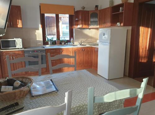 a kitchen with a white refrigerator and wooden cabinets at Kerca Bio Farm in Kercaszomor