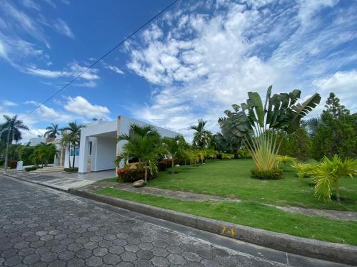 a building with a yard with palm trees in front of it at Casa Piscina Girardot Condominio Campestre in Flandes