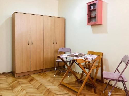 a table and chairs in a room with a cabinet at KRAGUJ apartments 1 in Kragujevac