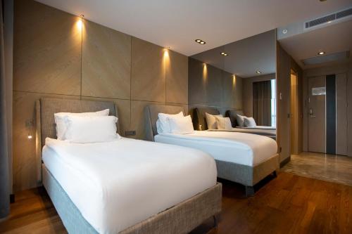 two beds in a hotel room with white pillows at Melas Hotel Istanbul in Istanbul