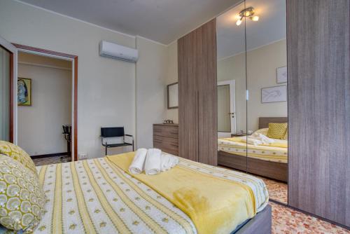 1 dormitorio con 2 camas y un espejo grande en CaseOspitali - CASA LUCE a due passi dal SAN RAFFAELE - 1 bedroom e divano in soggiorno, en Vimodrone