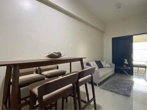 - un salon avec une table, des chaises et un canapé dans l'établissement 1BR Unit - MIGAs Haven @ One Pavilion Place, à Cebu