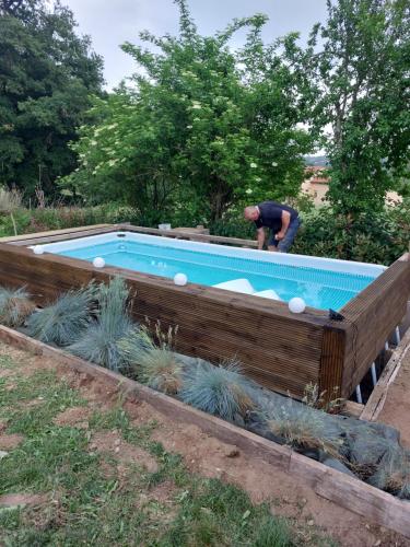 un homme debout en face d'une piscine dans l'établissement Dependance, à Youx