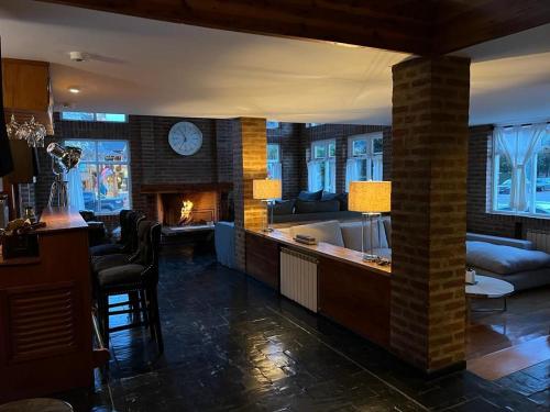 sala de estar con chimenea, sofá y mesa en Hosteria Las Walkirias en San Martín de los Andes