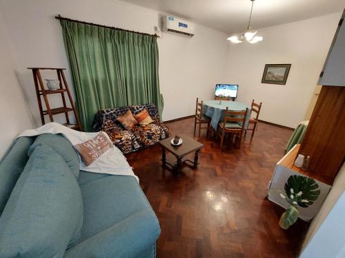 sala de estar con sofá azul y mesa en Departamento peatonal Mendoza en Mendoza