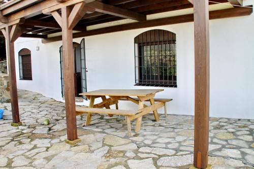 a wooden picnic table sitting under a pergola at Apartamento Playa Bolonia in Bolonia