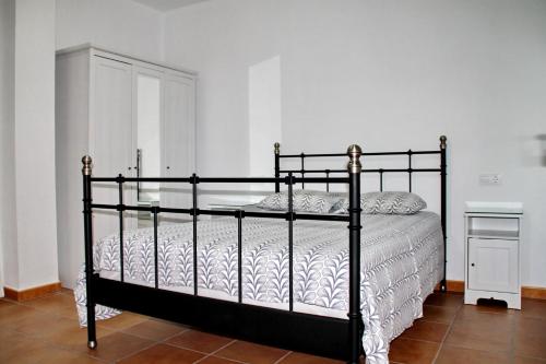 a bedroom with a black bed with white sheets at Apartamento Playa Bolonia in Bolonia