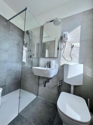a bathroom with a toilet and a sink and a shower at Hotel Terramare in Lido di Jesolo