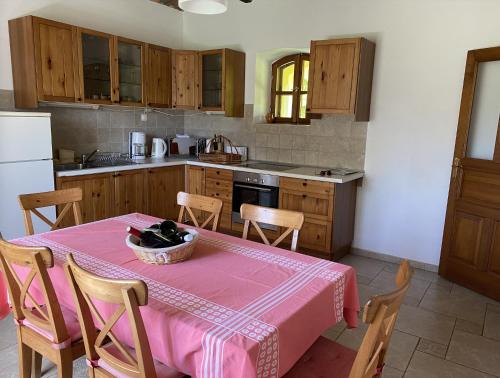 a kitchen with a table with a pink table cloth at Kerca Bio Farm in Kercaszomor