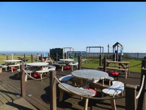 an empty playground with tables and a play structure at 18, Waterside park, Fernly Holiday Home in Corton