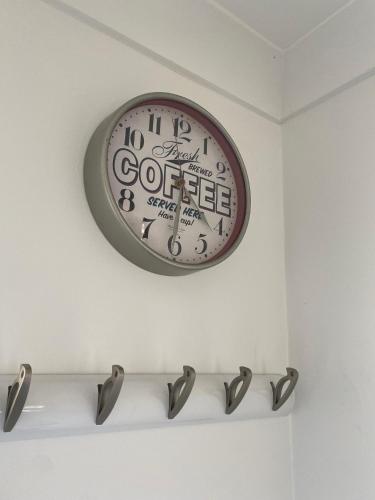 a clock is hanging on a white wall at 18, Waterside park, Fernly Holiday Home in Corton