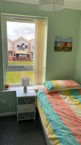 a bedroom with a bed and a window at Fernly Holiday Home in Corton