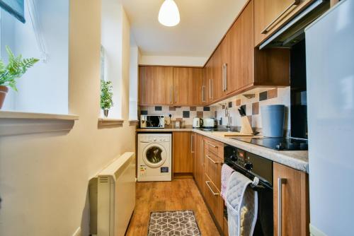 a kitchen with wooden cabinets and a washer and dryer at Florence Apartment - FREE PARKING in York