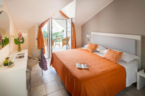 a bedroom with a bed with an orange bedspread at Diano Sporting Apartments in Diano Marina