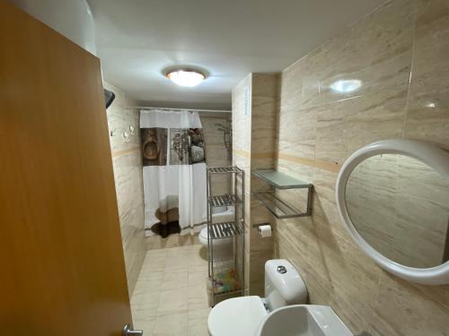 y baño con aseo blanco y espejo. en Apartamentos Punta Canaret Altamar, en Alcossebre