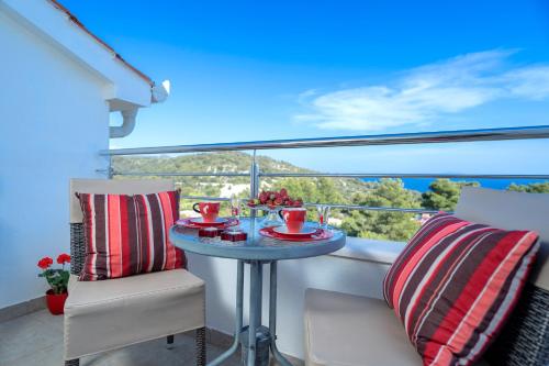 a table on a balcony with a bowl of fruit on it at Rooms & Studio Villa Fio in Hvar