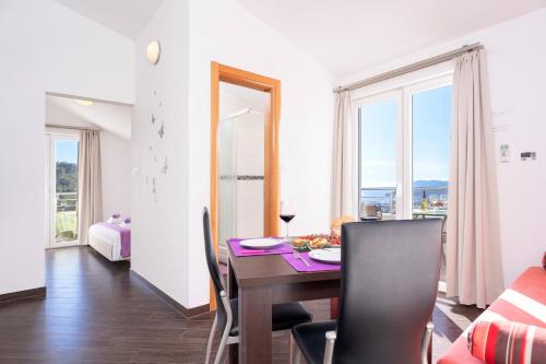 een eetkamer met een tafel en stoelen en een raam bij Villa Fio - Hvar in Hvar