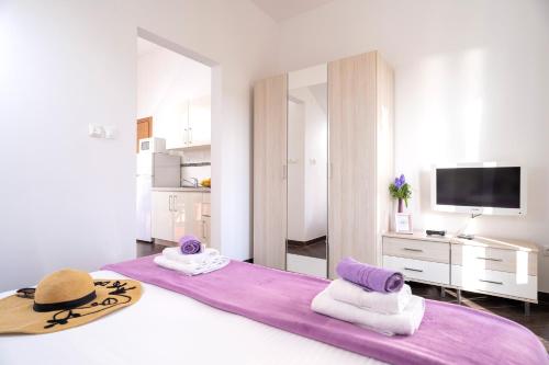 een slaapkamer met een groot bed met een hoed erop bij Villa Fio - Hvar in Hvar