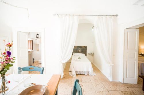 1 dormitorio con 1 cama en una habitación con paredes blancas en Trulli Nuova Aia Resort, en Alberobello