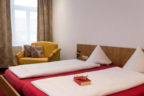a hotel room with two beds and a chair at Gasthof zum Hirsch in Görisried