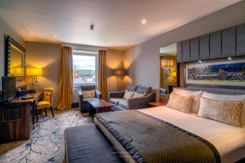 a hotel room with a large bed and a desk at City Hotel in Derry Londonderry