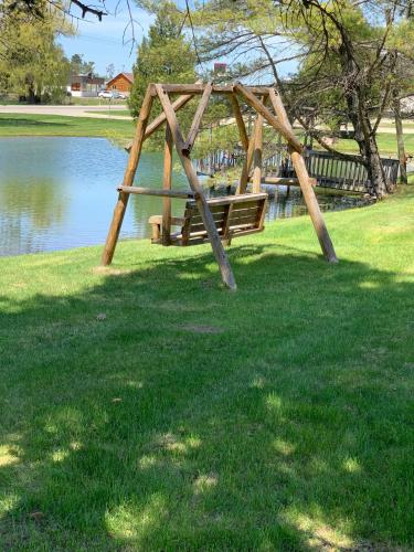 un columpio de madera en un parque junto a un lago en Tri Terrace Motel, en West Branch