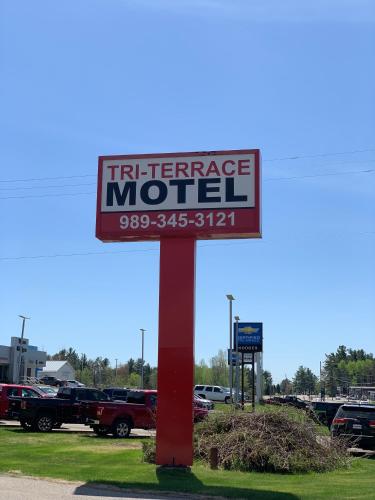 una señal para un motel de franquicia en un estacionamiento en Tri Terrace Motel, en West Branch