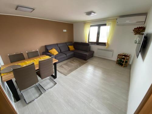 ein Wohnzimmer mit einem Sofa und einem Tisch in der Unterkunft Apartmány u Moravčíků in Bulhary