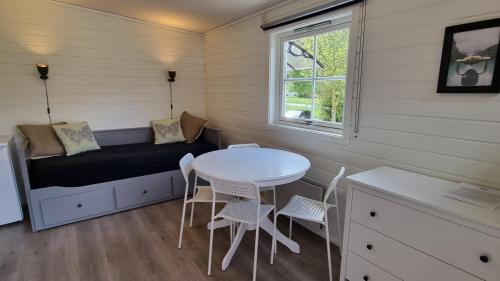 a small room with a table and chairs and a window at Skahjem Gard in Aurland