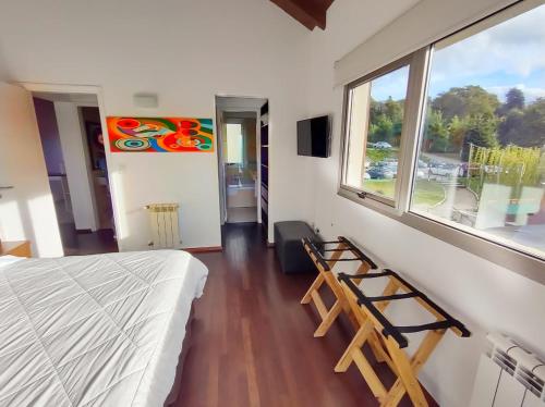 a bedroom with a bed and a window and a ladder at Quinta Luna NH in San Carlos de Bariloche