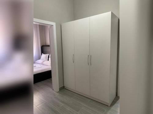 New New Bazaar في تيرانا: خزانة بيضاء في غرفة نوم بها سرير