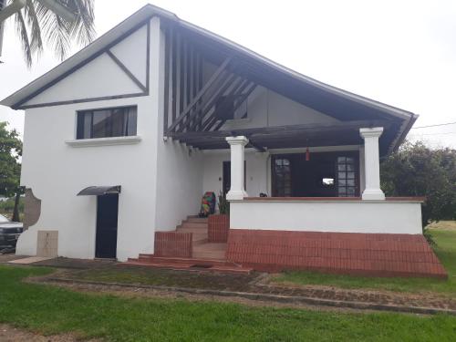 uma casa branca com um telhado preto em Conjunto vacacional Cocomar-Casa 6-4h em Carrizal