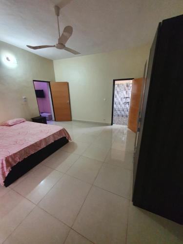 a bedroom with a bed and a ceiling fan at Appartement Meuble AU GOLF Bamako in Bamako
