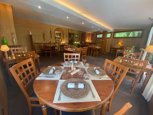 a dining room with a wooden table and chairs at Auberge Saint Fleuret in Estaing