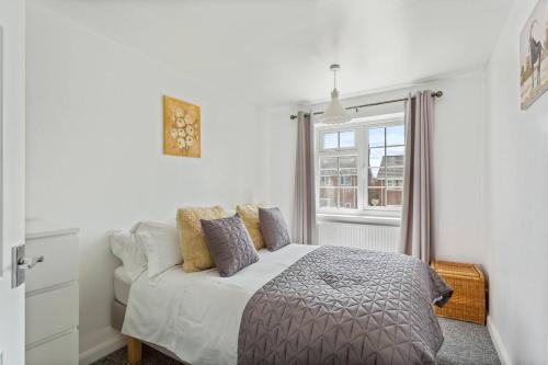 A bed or beds in a room at Bright & Spacious with Garden & Parking