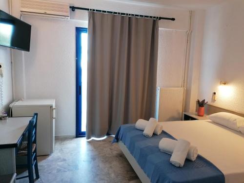 um quarto com 2 camas, uma secretária e uma janela em PIERIA MARE em Paralia Katerinis