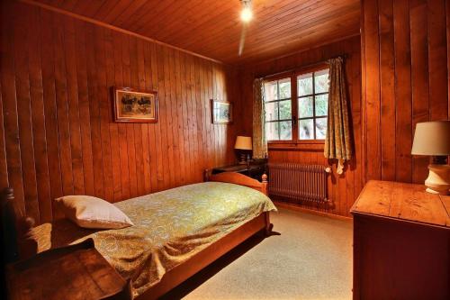 1 dormitorio con cama y ventana. en Chalet Nouchka VERB120, en Verbier