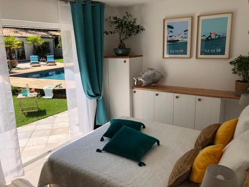 1 dormitorio con cama y vistas a la piscina en LA MAISON DE LA DUNE - Jacuzzi 1ère séance offerte - Piscine chauffée avec Abri Amovible - Plage située à 200m, accès direct par le bois en La Couarde-sur-Mer