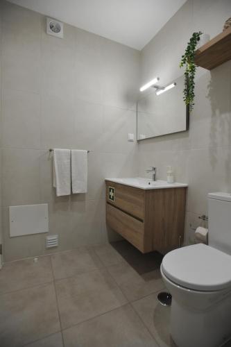 Un baño blanco con inodoro y lavabo. en Lagos Central Apartments Ap 10, en Lagos