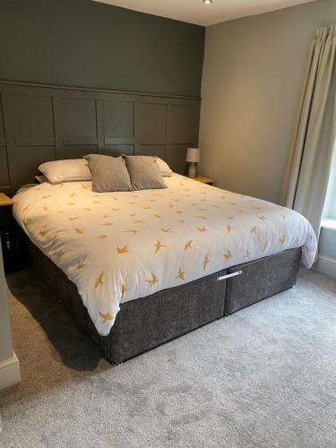 a bedroom with a large bed with a white comforter at Emelia Cottage Ingleton in Ingleton 