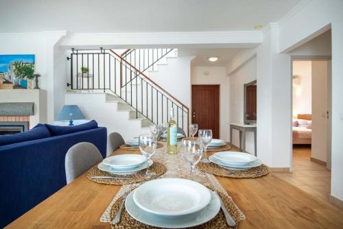 a dining room with a table with plates and wine glasses at Villa Estrella - Praia da Luz in Luz