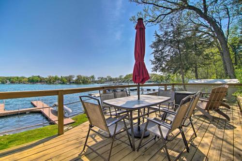 a table with an umbrella on a deck next to the water at Serene Lakefront Escape Boat Dock and Grill! in Twin Lakes