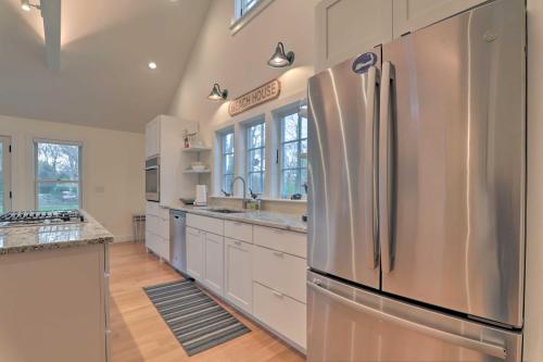 a large kitchen with a stainless steel refrigerator at Cape Cod Cottage with Fire Pit - Walk to Beach! in Brewster