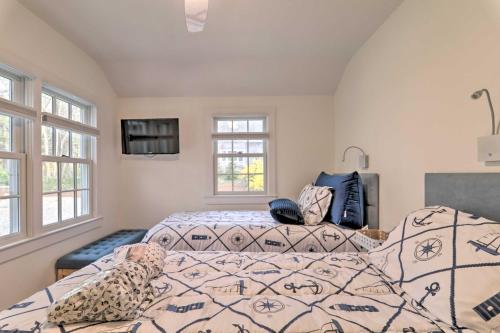 two beds in a room with two windows at Cape Cod Cottage with Fire Pit - Walk to Beach! in Brewster