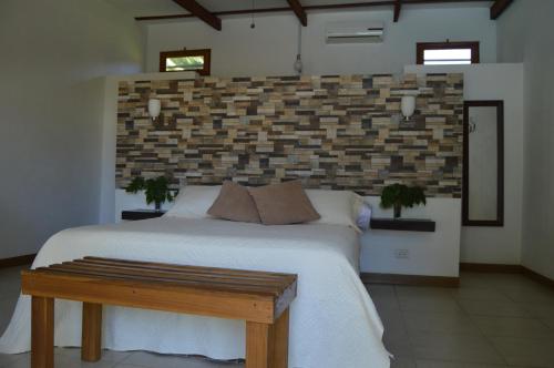 a large bed with a white bedspread in a room at Hotel Indalo adults only in Puerto Viejo