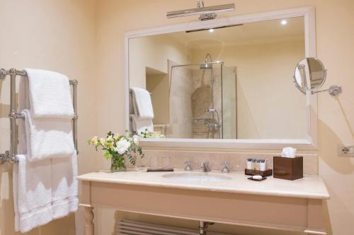 a bathroom with a sink and a large mirror at Il Borro Relais & Châteaux in San Giustino Valdarno