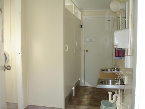 a small bathroom with a sink and a mirror at Alpine Holiday Apartments & Campground in Hanmer Springs